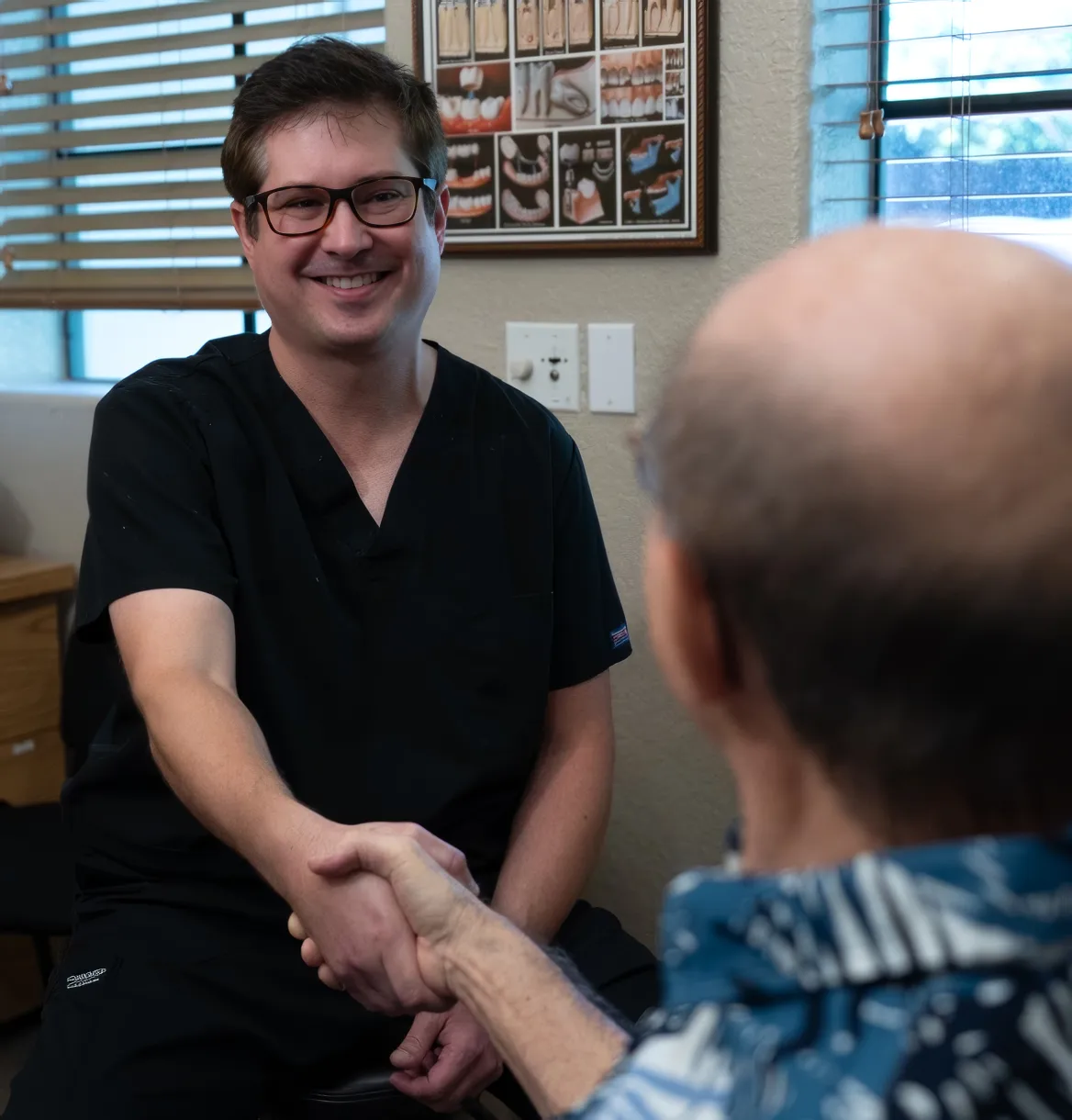 A Venetian Pointe dentist greeting a patient with a warm handshake